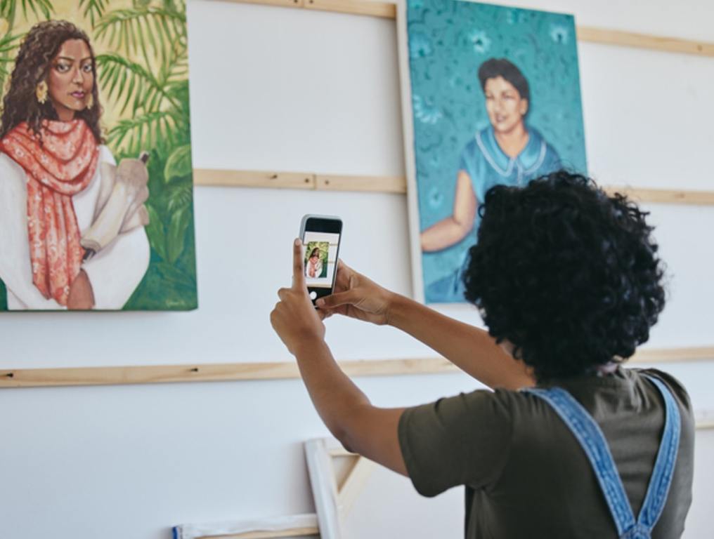 Art gallery, smartphone and black woman with painting taking photo for social media, website or digital advertising. African artist portrait design canvas, cellphone photography for commercial sales, black history month concept